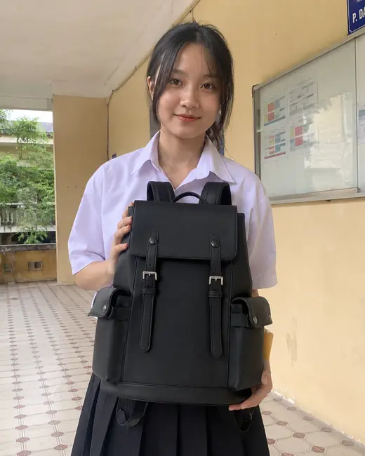 Bạn nữ ôm balo Guardian màu đen trước ngực trong lớp học