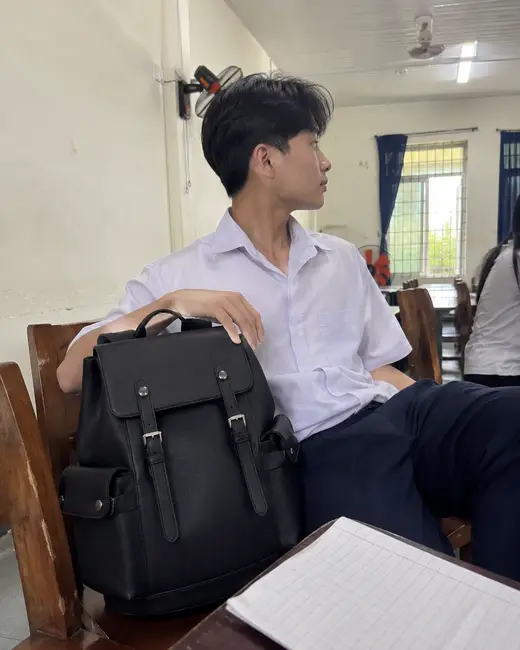 Balo Guardian màu đen đặt trên bàn học cạnh bạn nam