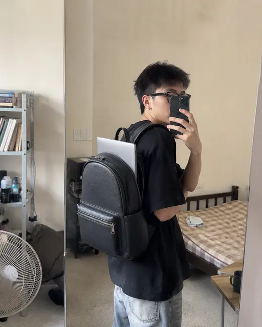 Ảnh chụp gương một bạn nam đeo balo màu đen